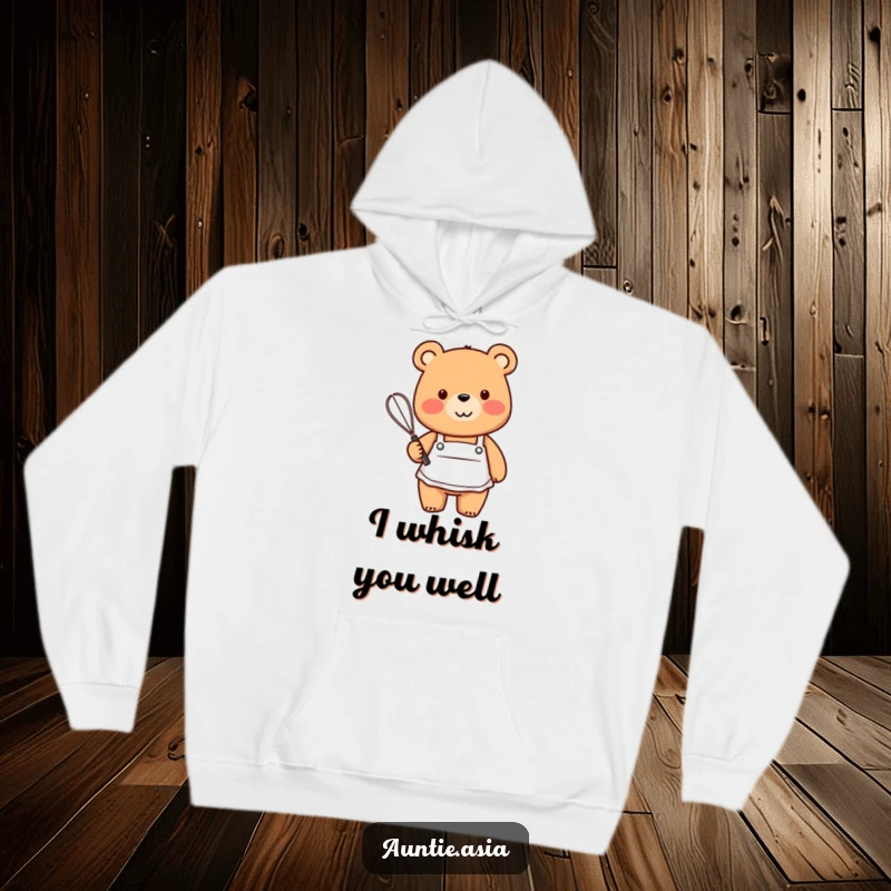 Funny friendly bear in a small apron, holding a whisk with a smile, a cozy and humorous hoodie.